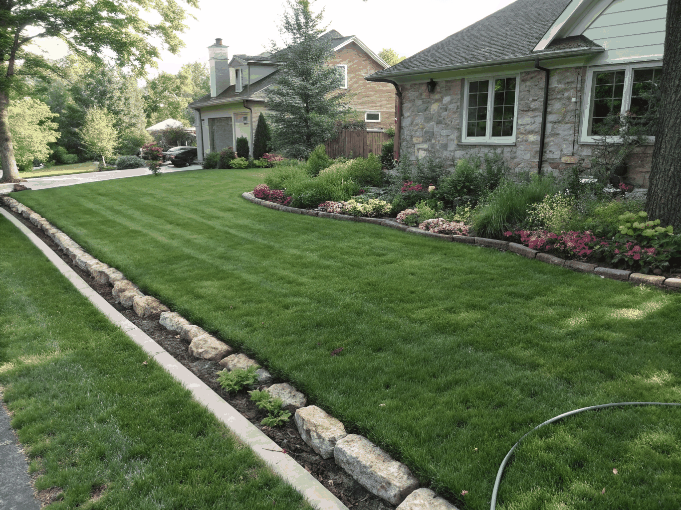 Transformed residential front yard with lush grass and neat garden beds in Conway, Arkansas
